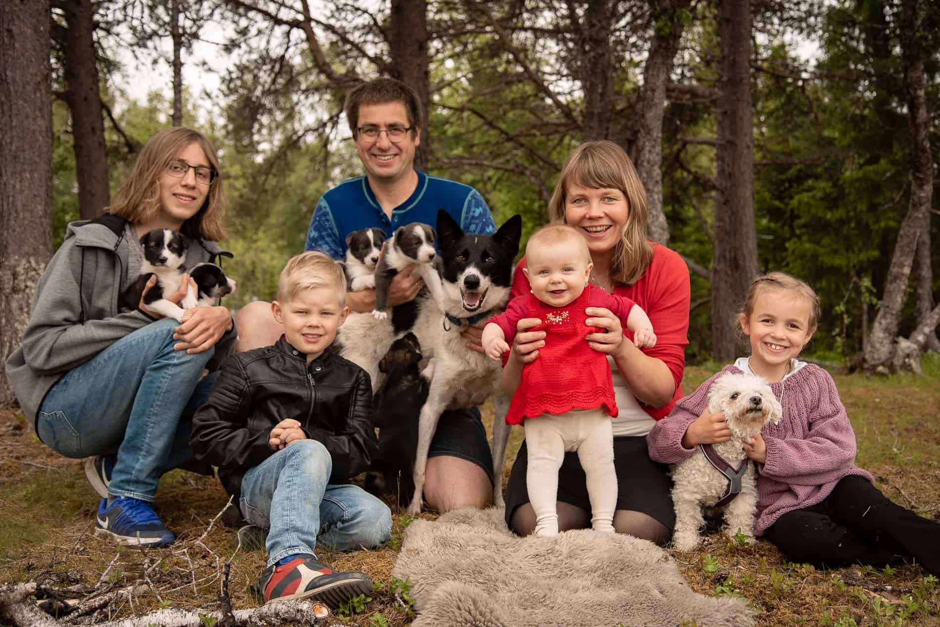 Familiefotografering med familie og hunder i skogsmiljø.
