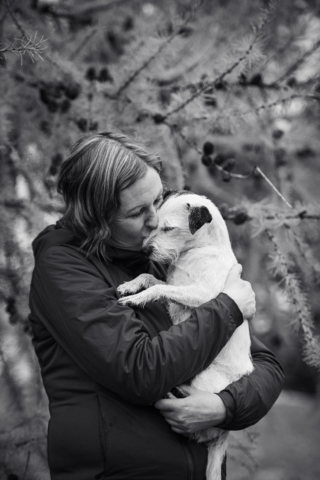 Familiefotografi av kvinne og hund i naturen.