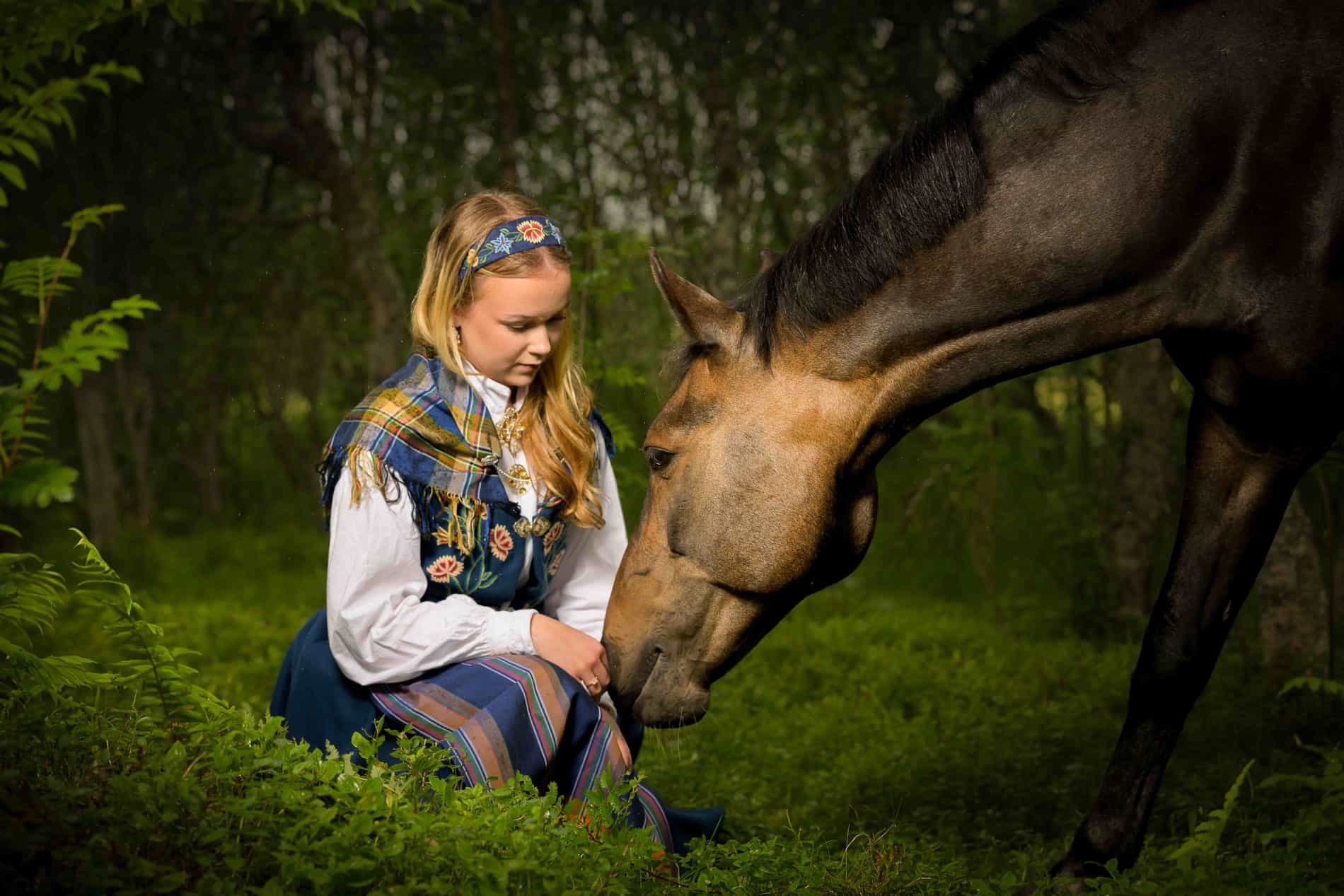 Jente og hest som møtes i naturen under familiefotografering.